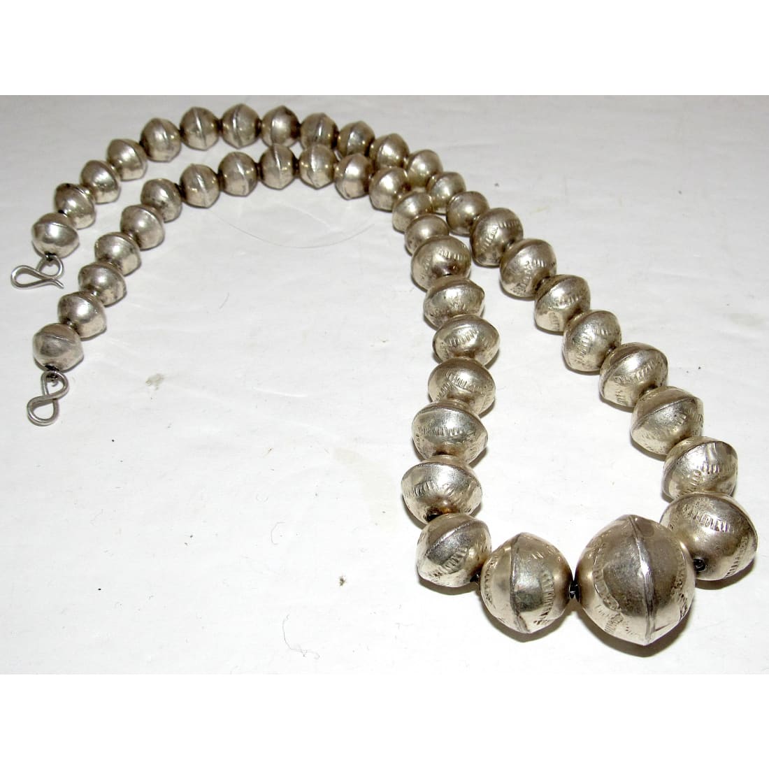 Navajo pearls necklace featuring graduated hand stamped sterling silver beads, measuring 18 inches long.