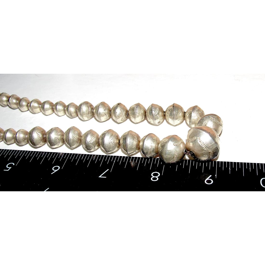 Navajo pearls necklace with graduated beads, hand stamped sterling silver, measuring 18" long.