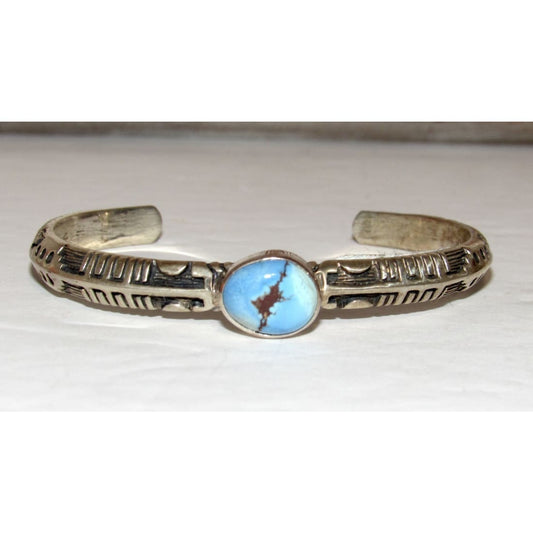 Navajo Golden Hills turquoise sterling bracelet with intricate silver etching and central blue stone