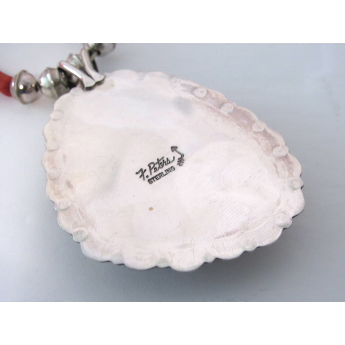 Back view of Native American Royston turquoise pendant coral necklace showing sterling silver hallmark