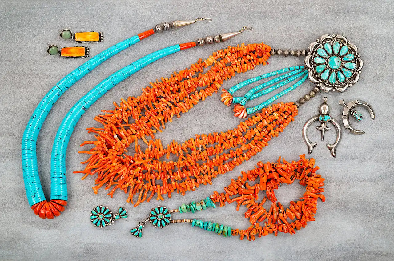 Native American turquoise and coral jewelry pieces arranged in a decorative pattern.