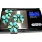 Sonoran gold turquoise dangle earrings with multiple turquoise stones displayed on a digital scale