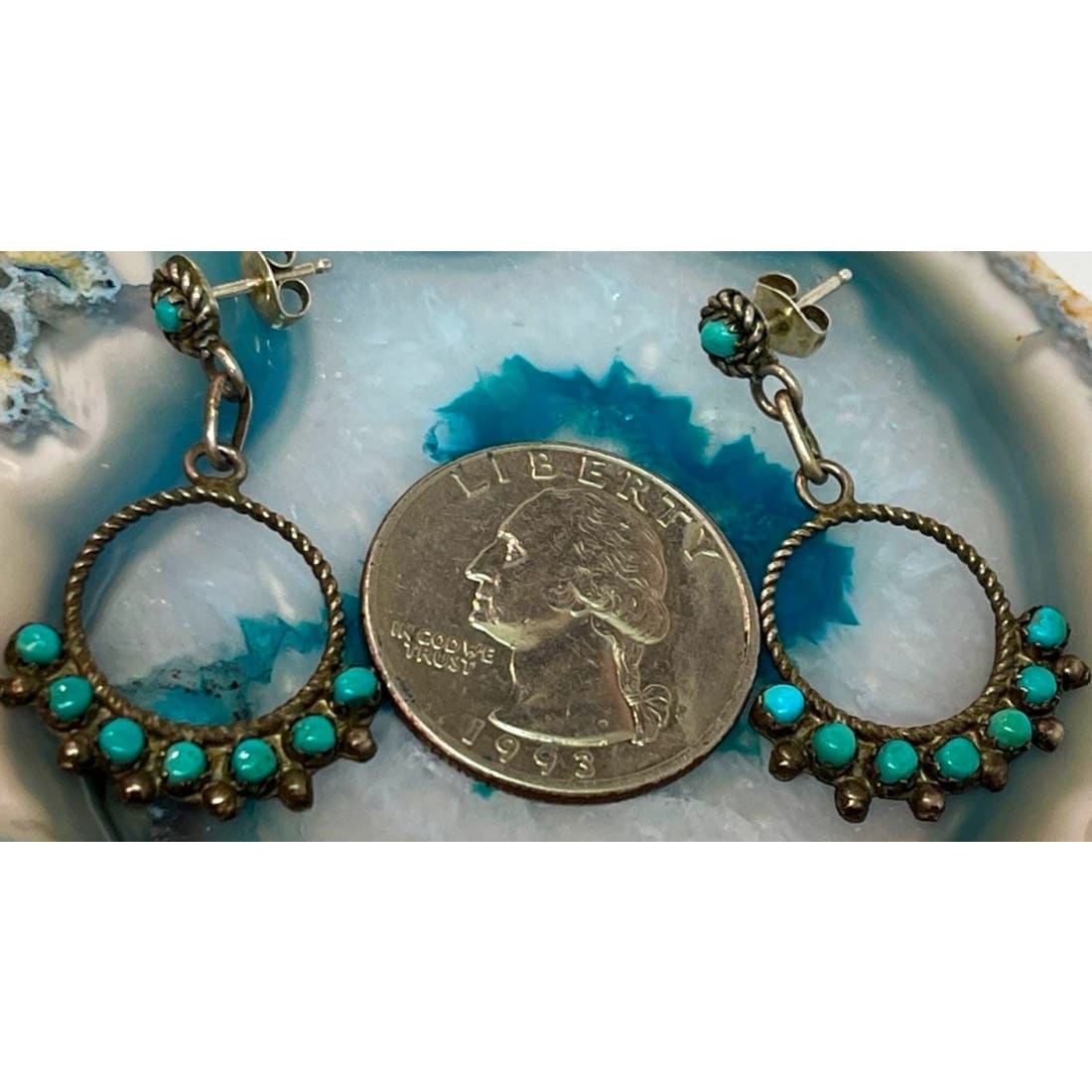 Native American Zuni snake eye turquoise earrings with circular design displayed next to a quarter for size comparison