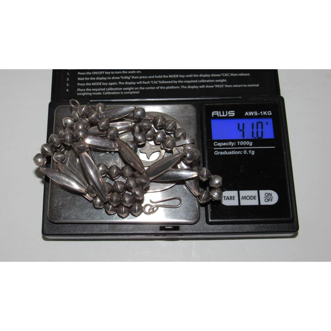 Vintage Navajo squash blossom necklace in silver displayed on digital scale showing weight